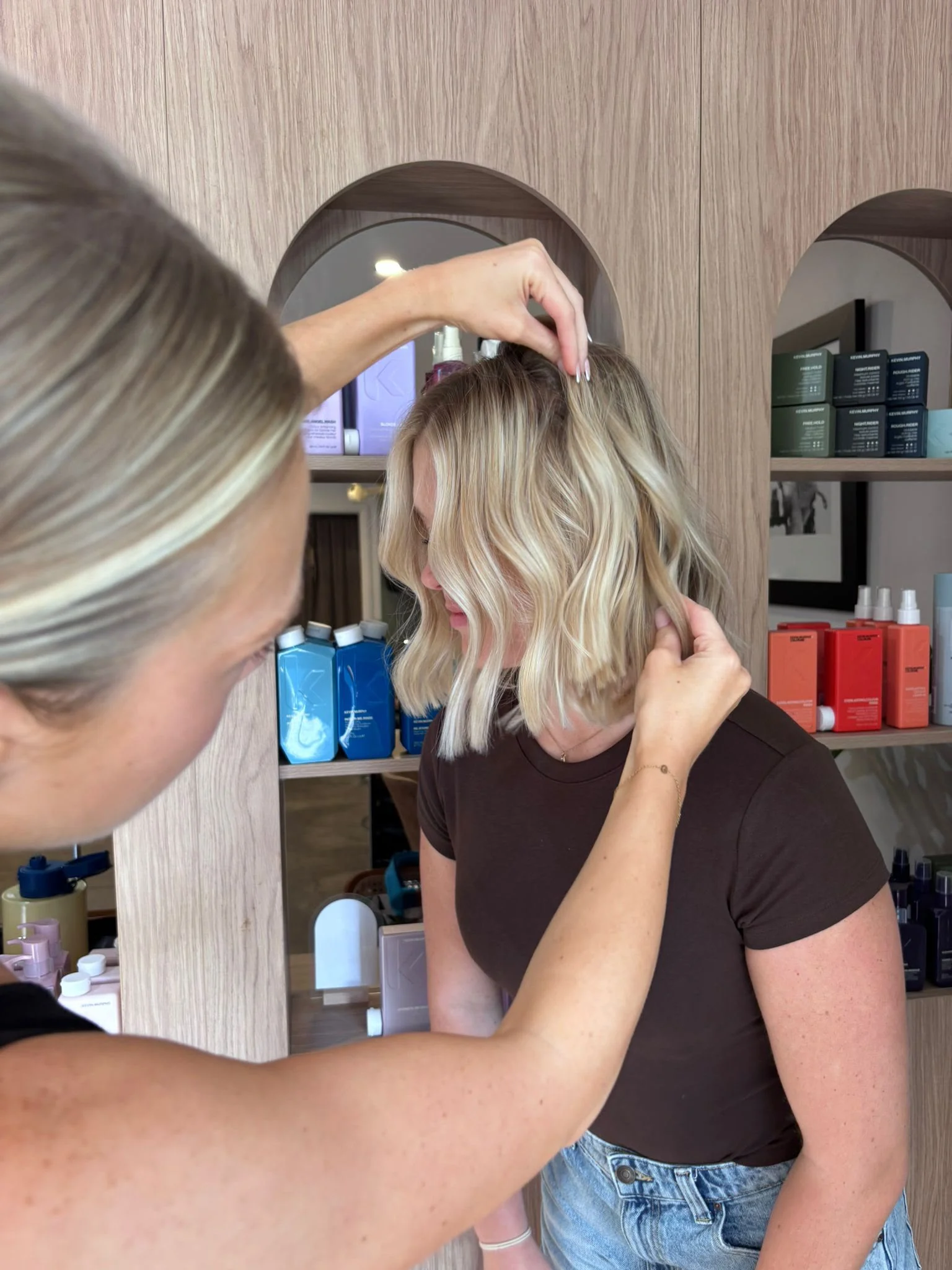 A Radical Hair stylist finishing a client's blonde bob in the Dural salon